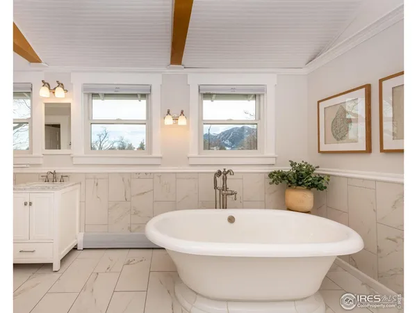 a white bath tub sitting in a bathroom next to a window