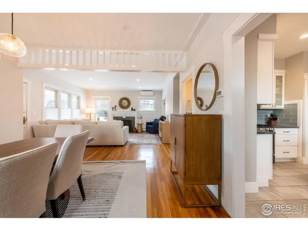 a living room with furniture a mirror and white walls