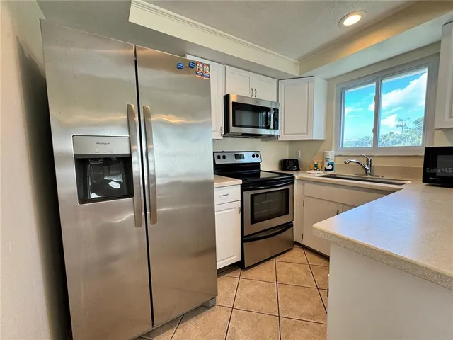 a kitchen with stainless steel appliances a refrigerator sink and microwave