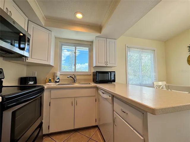 a kitchen with a sink stove top oven and cabinets