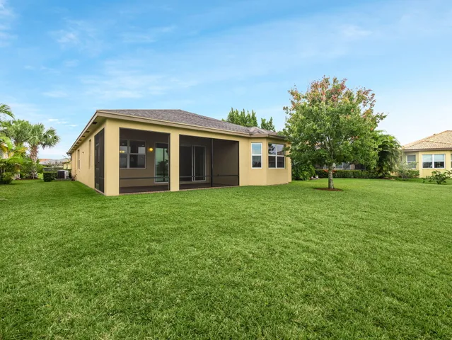 an aerial view of a house with a yard and a large trees
