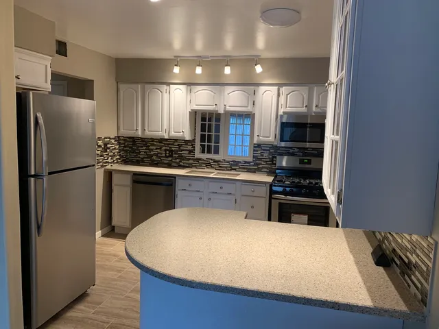 a kitchen with stainless steel appliances a refrigerator a stove and a sink