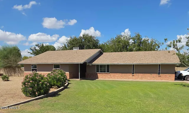 a view of a house with a yard and potted plants