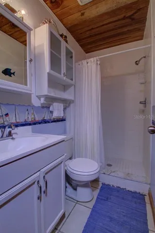 a bathroom with a sink a toilet a mirror and shower