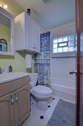 a living room with furniture and a refrigerator