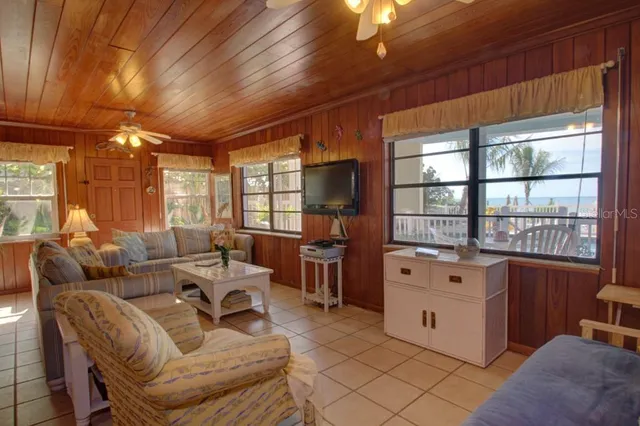 a living room with furniture a large window and a chandelier