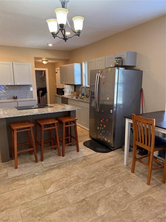 809 South Wine Street Gainesville, TX 76240 - Photo 9 of 33 a kitchen with stainless steel appliances granite countertop a table chairs and a refrigerator