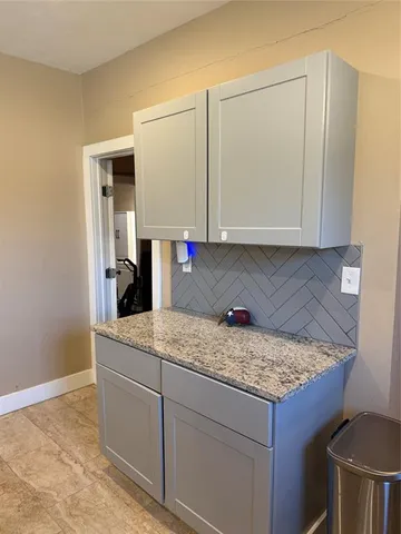 a kitchen with stainless steel appliances granite countertop a table chairs and a refrigerator