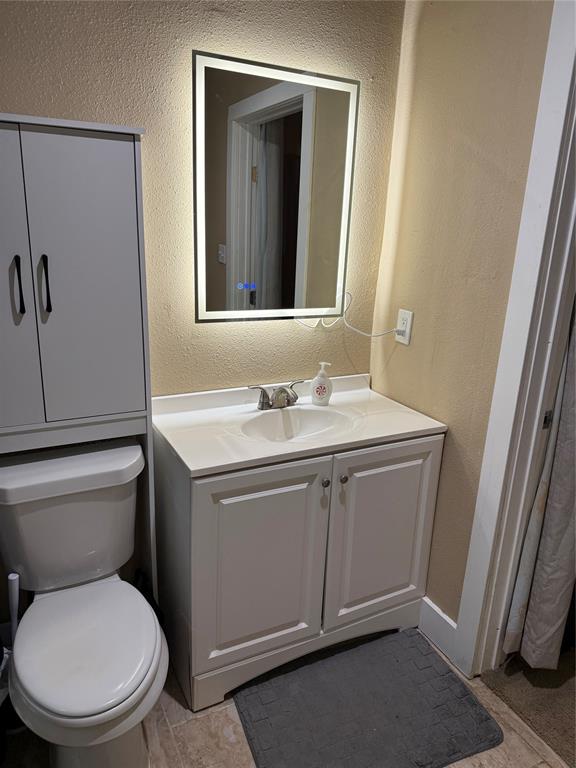 809 South Wine Street Gainesville, TX 76240 - Photo 16 of 33 a bathroom with a toilet sink and mirror