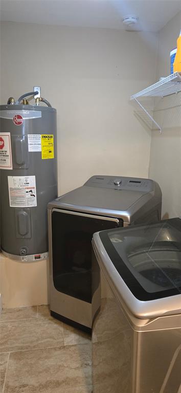 809 South Wine Street Gainesville, TX 76240 - Photo 27 of 33 Laundry room featuring electric water heater and washer and dryer