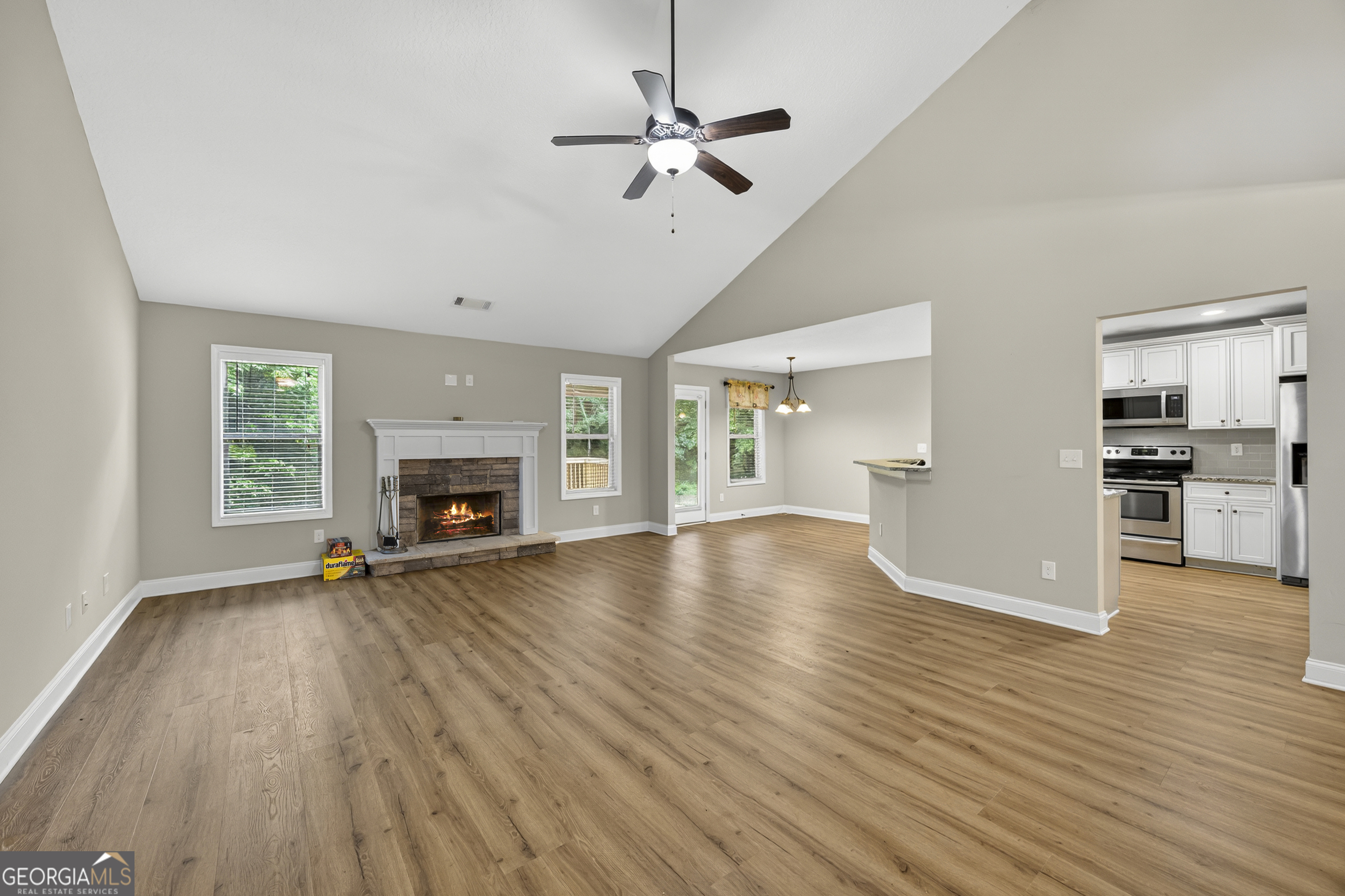717 Oconee Lane Commerce, GA 30529 - Photo 13 of 57 an empty room with wooden floor fireplace and a window