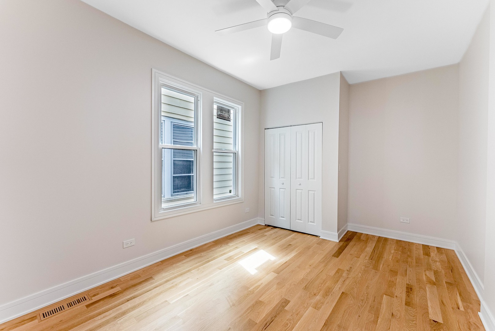 822 North Lockwood Avenue Chicago, IL 60651 - Photo 19 of 63 an empty room with wooden floor fan and windows