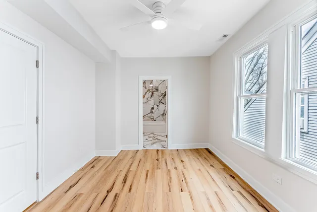 a view of empty room with wooden floor and closet