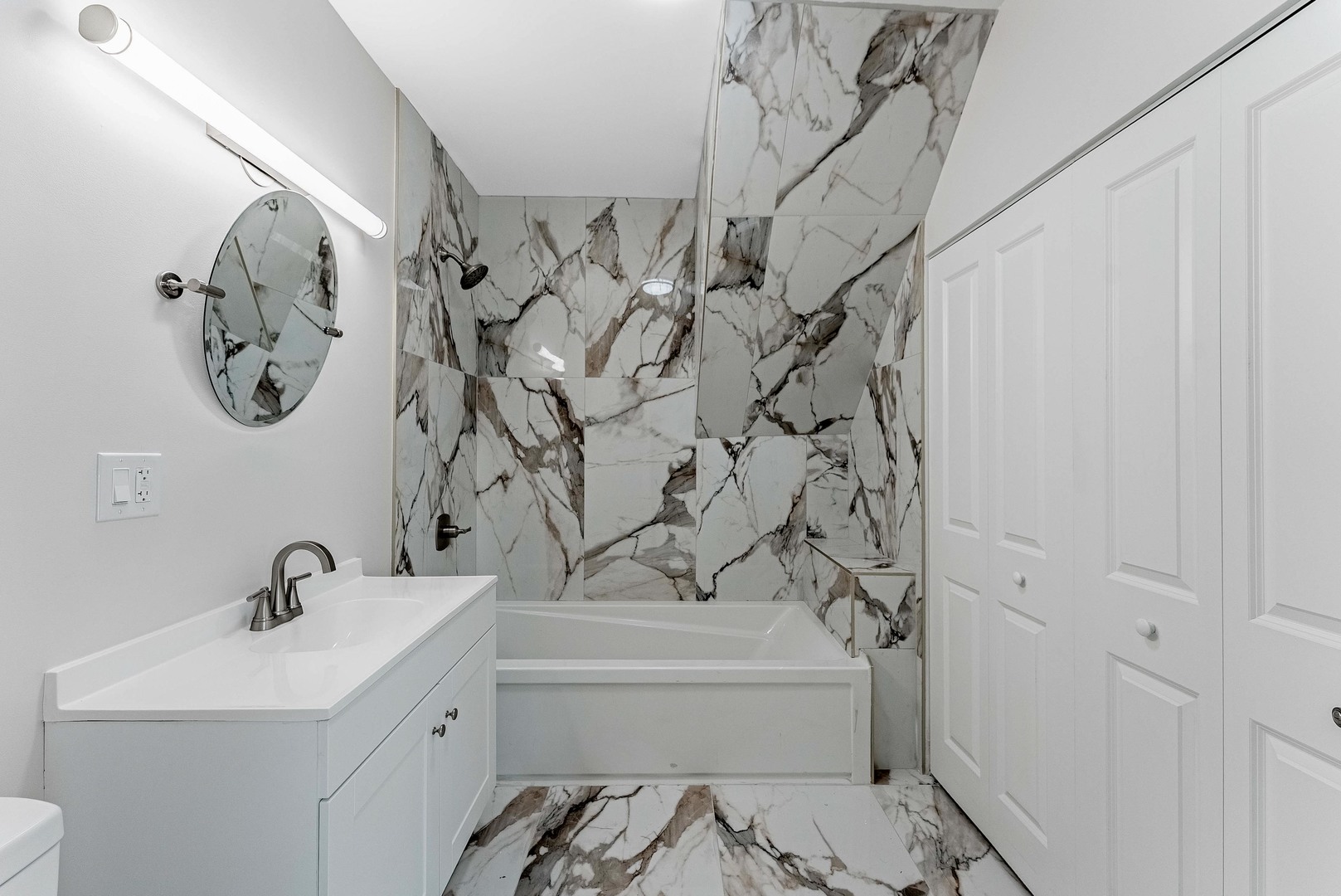 822 North Lockwood Avenue Chicago, IL 60651 - Photo 34 of 63 a bathroom with a sink and mirror with bathtub