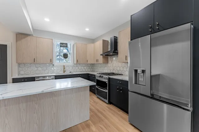 a kitchen with stainless steel appliances granite countertop a sink stove and refrigerator