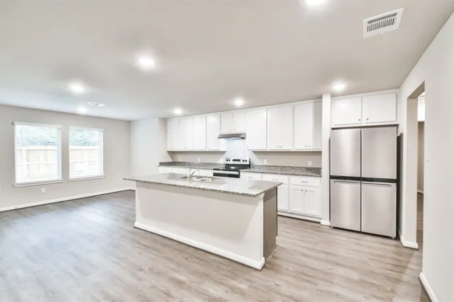 a kitchen with a refrigerator a stove a sink and a microwave