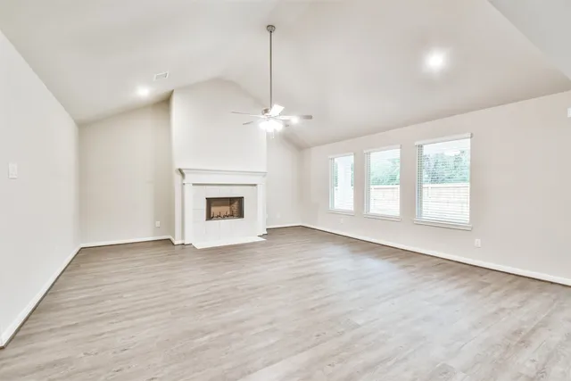 a view of an empty room with a fireplace and a window
