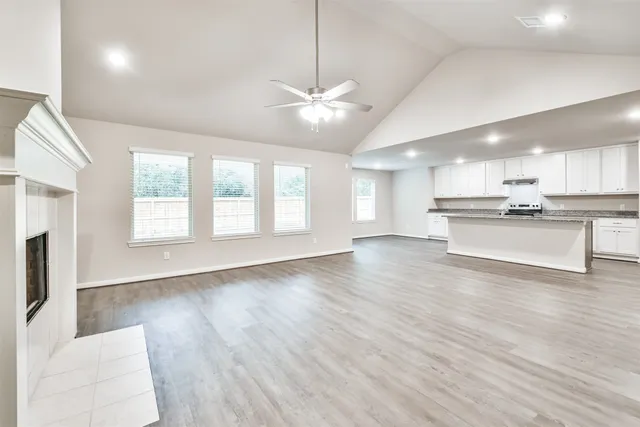 a view of an empty room with window and wooden floor