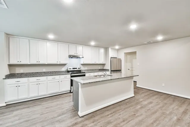 a kitchen with stainless steel appliances granite countertop a sink and cabinets