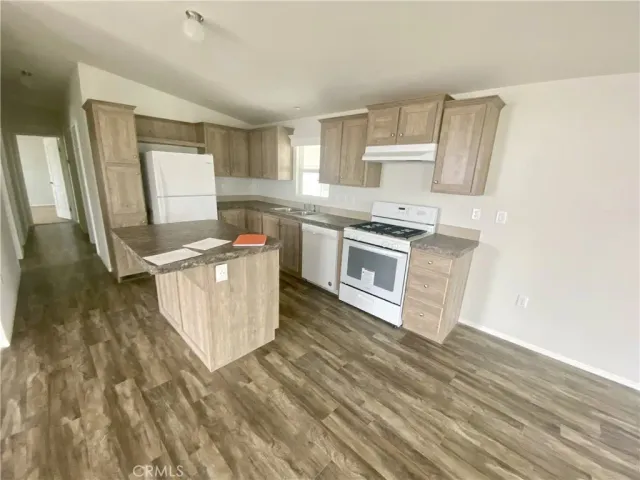 a kitchen with stainless steel appliances granite countertop a stove a sink and a refrigerator