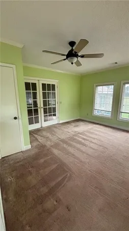 a view of an empty room with a window and a kitchen