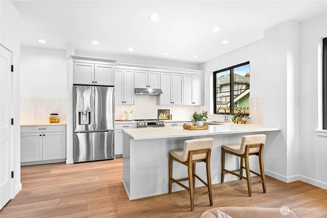 a kitchen with white cabinets and stainless steel appliances