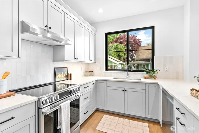 a kitchen with stainless steel appliances granite countertop a sink and a stove