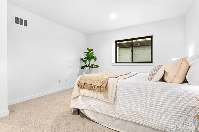 a bedroom with a bed and a potted plant