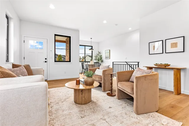a living room with furniture a rug and a potted plant