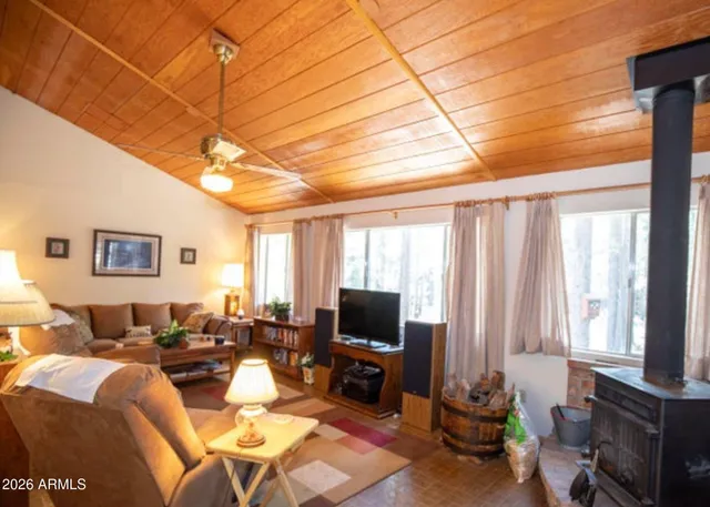 a living room with furniture a flat screen tv and a window