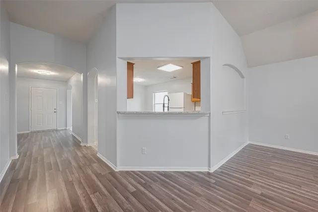 a view of a room with wooden floor and a mirror