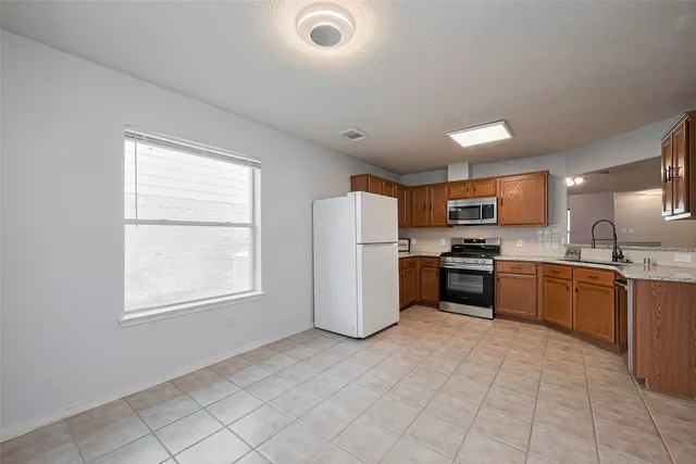 a kitchen with stainless steel appliances granite countertop a refrigerator sink and stove
