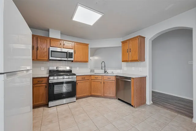 a kitchen with stainless steel appliances granite countertop a sink and a stove top oven