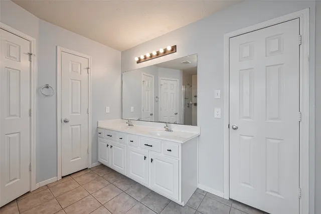 a bathroom with a double vanity sink and a mirror