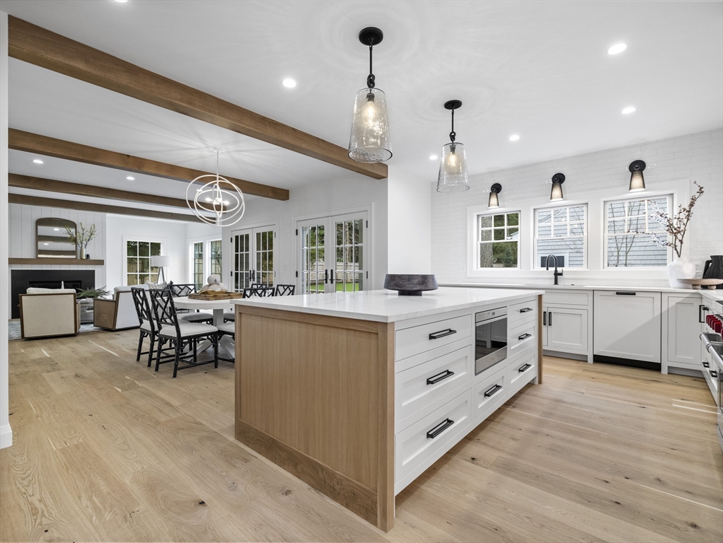 77 Forest Street Wellesley, MA 02481 - Photo 4 of 32 a large white kitchen with kitchen island a large island in the center