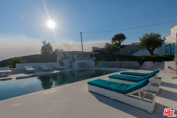 a swimming pool with barbeque oven and outdoor seating