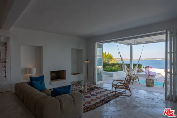 a living room with furniture a flat screen tv and a large window