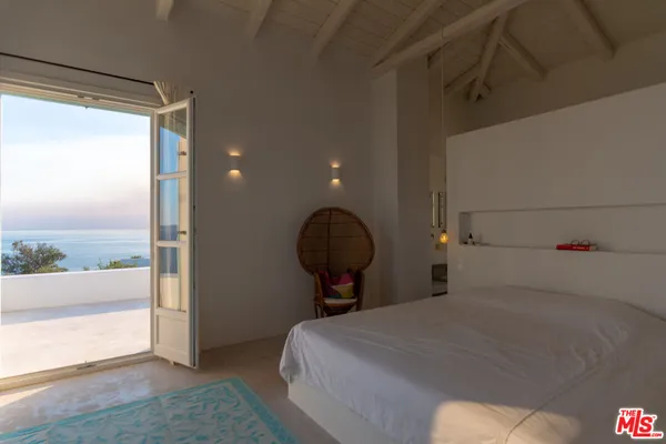 a bedroom with a bed and a lamp with the wooden floor