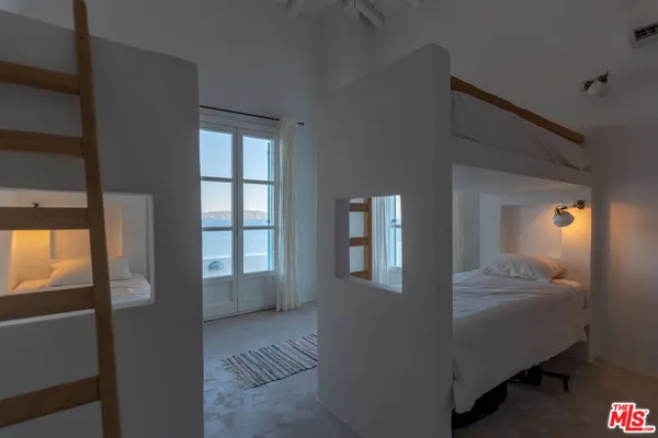 a bedroom with a bed and a lamp on the dresser