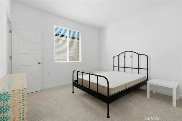 a spacious bedroom with a bed and a chair