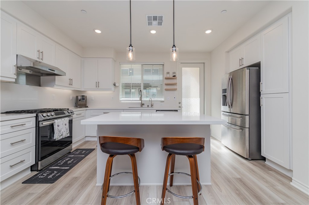 2425 Villena Way Placentia, CA 92870 - Photo 7 of 35 a kitchen with stainless steel appliances a stove a sink cabinets and wooden floor
