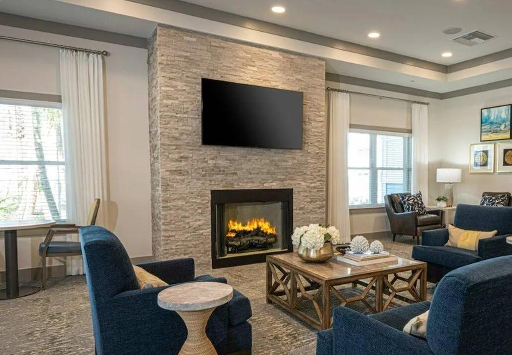 1900 Northwest Federal Highway Stuart, FL 34994 - Photo 10 of 15 a living room with furniture a flat screen tv and a fireplace