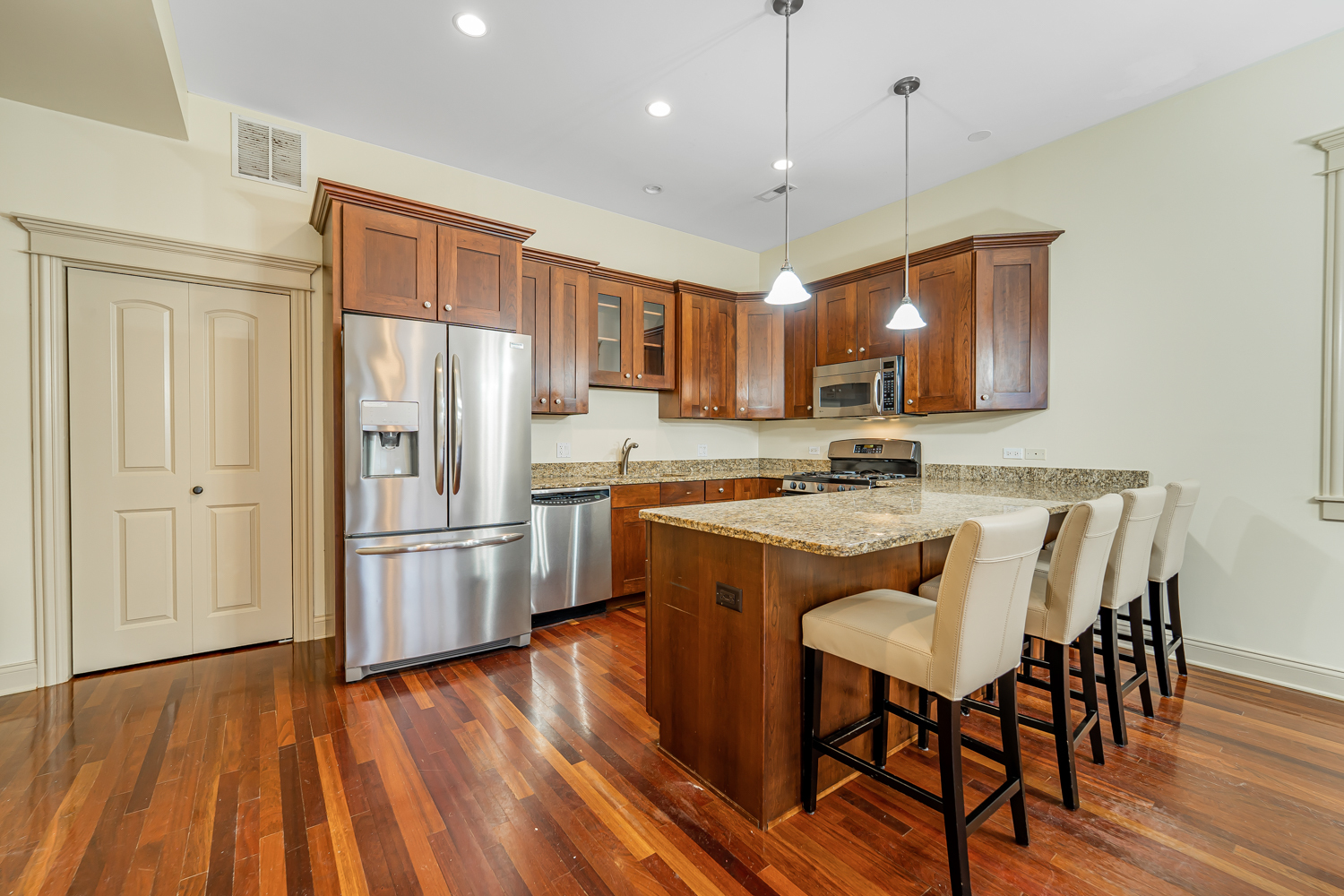 1018 South May Street, Unit F Chicago, IL 60607 - Photo 2 of 21 a kitchen with kitchen island granite countertop a sink a center island and stainless steel appliances