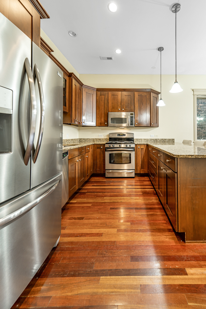 1018 South May Street, Unit F Chicago, IL 60607 - Photo 4 of 21 a kitchen with stainless steel appliances granite countertop a refrigerator a stove and a wooden floors
