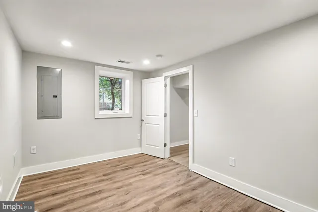 a view of empty room with wooden floor