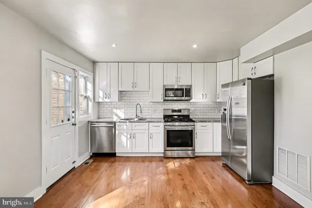 a kitchen with stainless steel appliances granite countertop a refrigerator stove top oven and sink