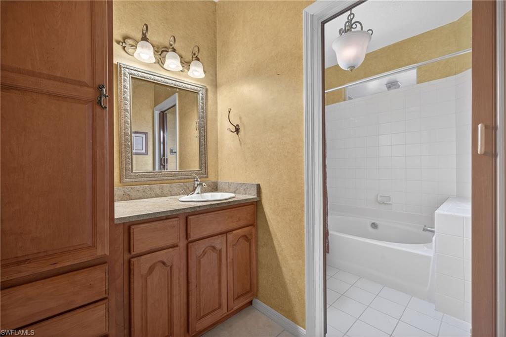 290 Emerald Bay Circle, Unit L7 Naples, FL 34110 - Photo 11 of 22 a bathroom with a tub sink and mirror
