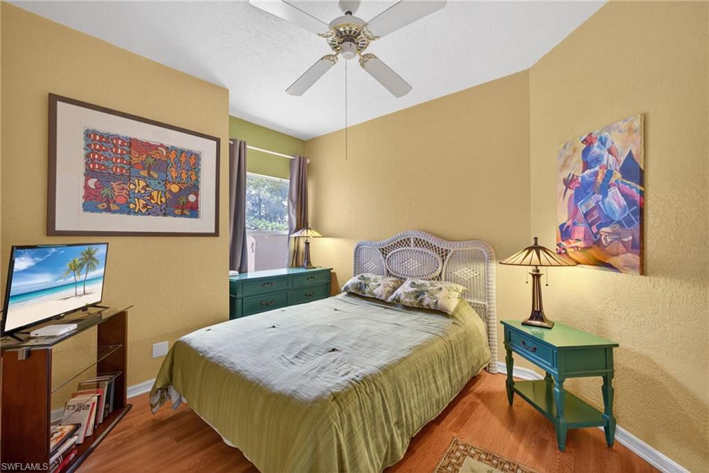 290 Emerald Bay Circle, Unit L7 Naples, FL 34110 - Photo 12 of 22 a bedroom with a bed and a chandelier