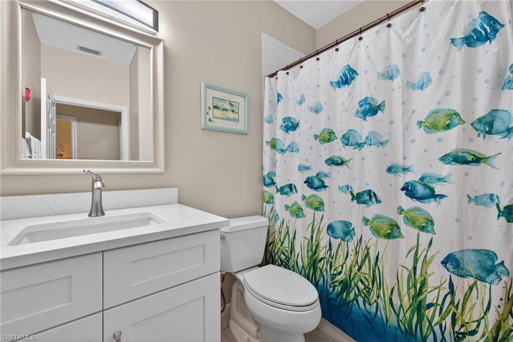 290 Emerald Bay Circle, Unit L7 Naples, FL 34110 - Photo 13 of 22 a bathroom with a toilet sink and mirror