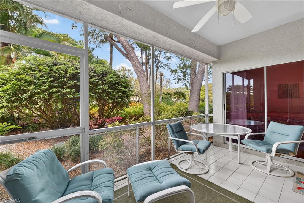 290 Emerald Bay Circle, Unit L7 Naples, FL 34110 - Photo 15 of 22 a living room with furniture and floor to ceiling windows
